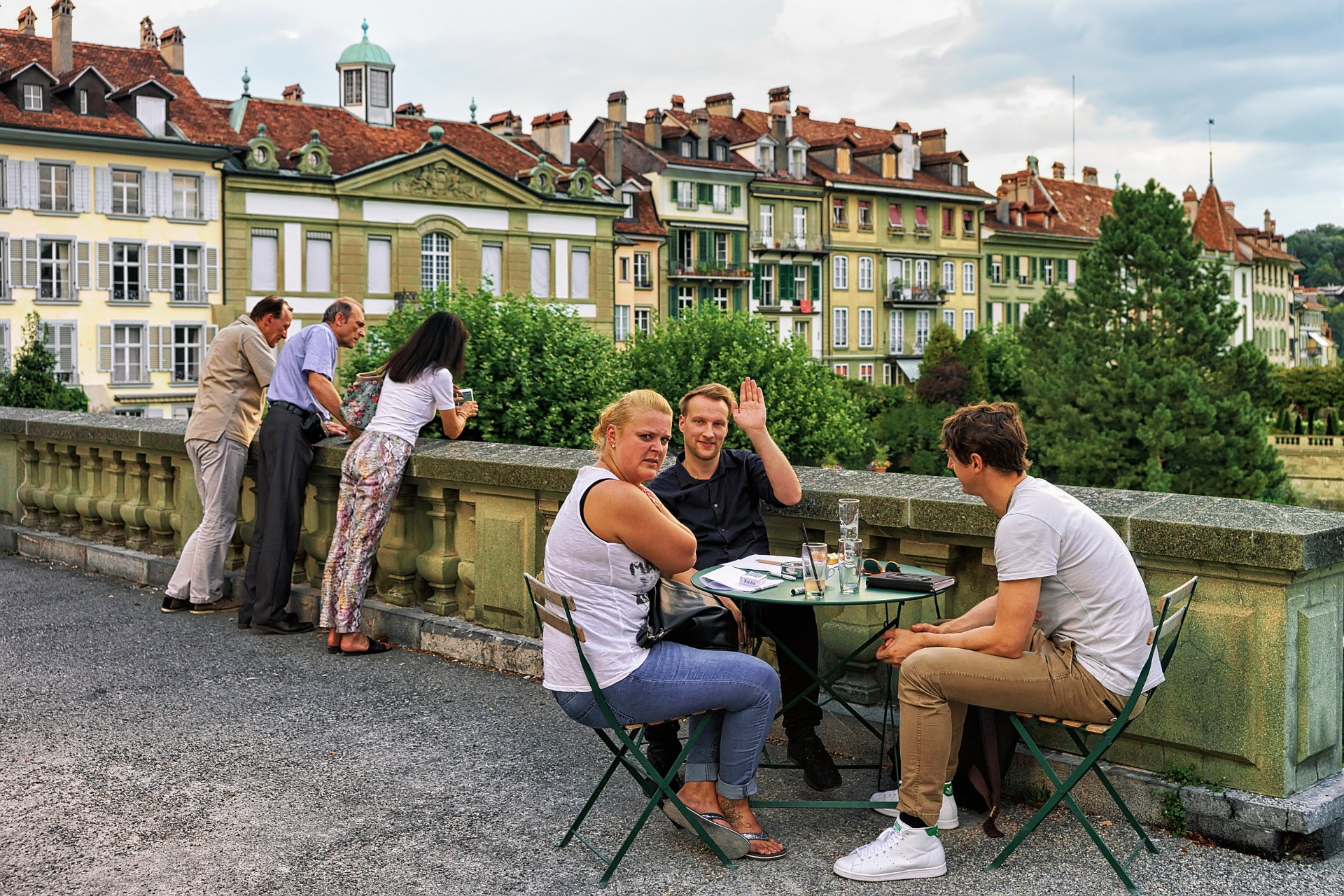 Amigos en la mesa de un café al aire libre en la terraza Münsterplattform, en el casco antiguo de Berna